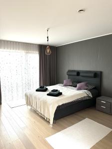 a bedroom with a large bed with a large window at A Cozy Retreat - Sauna & Garden - 3BDR in Pärnamäe