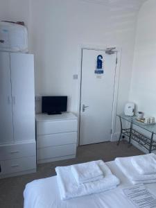 a room with a bed with two white towels on it at Seaview Sanctuary in Eastbourne