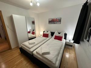 1 dormitorio con 1 cama grande con almohadas rojas en Maisonette-Apartment mit großer Terrasse im Zentrum von Bregenz, en Bregenz