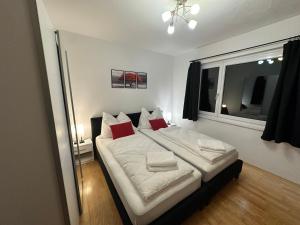 una camera da letto con un grande letto con cuscini rossi di Maisonette-Apartment mit großer Terrasse im Zentrum von Bregenz a Bregenz