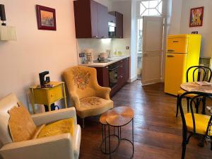 eine Küche mit 2 Stühlen und einem Tisch in einem Zimmer in der Unterkunft Meublé de tourisme Art§Vintage in Oloron-Sainte-Marie + 12 Fotos