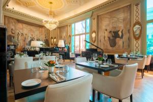 une salle à manger avec des tables et des chaises ainsi qu'un lustre dans l'établissement Grand Hotel Palace Rome, à Rome