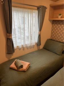 a bed in a bedroom with a window at Olive-Grove in Kent