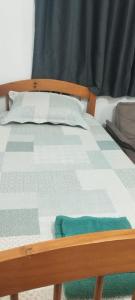 a bed with a blue and white quilt on it at Pousada da Vila 1 in Araçariguama