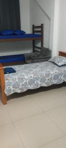 Cette chambre comprend 2 lits et une table avec un couvre-lit. dans l'établissement Pousada da Vila 1, à Araçariguama