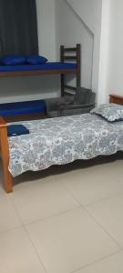 a room with two beds and a table with a bedspread at Pousada da Vila 1 in Araçariguama