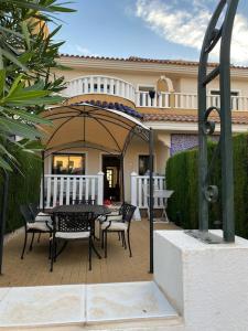 eine Terrasse mit Tisch und Stühlen vor einem Haus in der Unterkunft Prestigious Dona Pepa 2 Urbanisation with Shared Pool in Ciudad Quesada