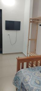 a room with a flat screen tv on the wall at Pousada da Vila 1 in Araçariguama
