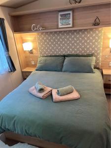 ein Bett mit zwei Handtüchern darüber in der Unterkunft Olive-Grove in Kent