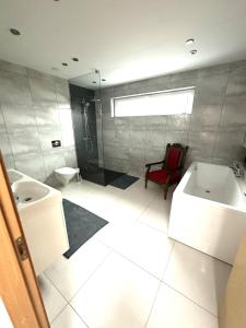 La salle de bains est pourvue d'une baignoire, de toilettes et d'un lavabo. dans l'établissement A Cozy Retreat - Sauna & Garden - 3BDR, à Pärnamäe