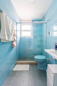 a blue bathroom with a toilet and a shower at Amplo apartamento Barra Salvador in Salvador