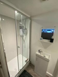 a bathroom with a shower and a toilet and a television at LT Apartments 56 - Free St parking in Leicester