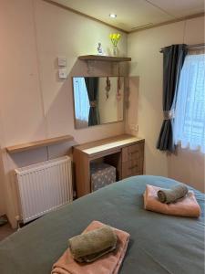 a bedroom with a bed with two towels on it at Olive-Grove in Kent