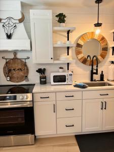 a kitchen with white cabinets and a microwave at Cracker Cow Cottages - Cottage B in Fort Myers