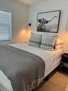 a bedroom with a bed with a picture of a cow at Cracker Cow Cottages - Cottage B in Fort Myers