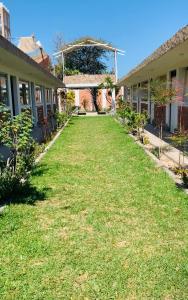 a yard of a house with a lawn at HOTEL REAL BERNAL in Chincha Alta