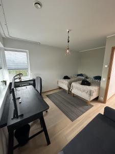 - un salon avec deux lits et une table dans l'établissement A Cozy Retreat - Sauna & Garden - 3BDR, à Pärnamäe