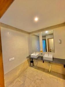 a bathroom with two sinks and a large mirror at SYLVAN RESORTS - Mountain View in Solan
