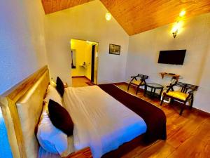 a bedroom with a large bed and a table at SYLVAN RESORTS - Mountain View in Solan