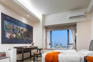 a bedroom with a bed and a desk and a large window at Orange Apartments in Chengdu