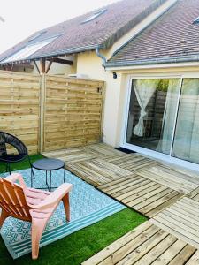 a wooden deck with a table and a chair at Cocon Maritime 1 chambre & 1 Mezzanine in Ouistreham