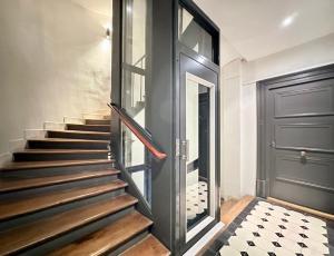 a staircase with a black door and a tile floor at 1570 - Luxury spot in Paris Olympic Games 2024 in Paris