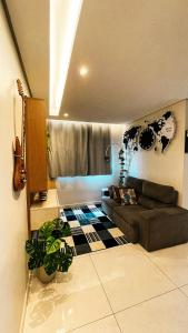 a living room with a couch and a guitar at Stúdio Moderno Cama de Massagem! in Uberlândia