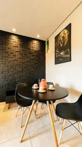 a dining room with a black table and chairs at Stúdio Moderno Cama de Massagem! in Uberlândia