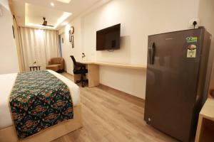 Habitación de hotel con cama y nevera en Diona Anukampa Suite Room with rooftop pool, en Jaipur