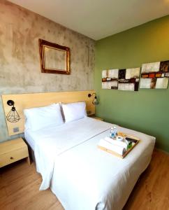 Un dormitorio con una cama blanca y una bandeja. en Raintree Boutique Hotel en Kajang