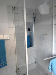 a white bathroom with a tub and a shower at Ferienwohnung Schröder in Putbus