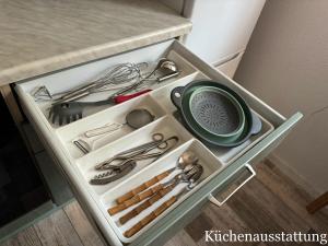 a drawer full of kitchen utensils in a cabinet at Ferienwohnung Schröder in Putbus