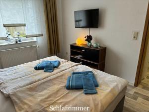 a bedroom with a bed with blue towels on it at Ferienwohnung Schröder in Putbus