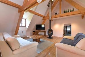 a living room with two couches and a tv at Belle Maison Alsacienne de 1610 in Gueberschwihr
