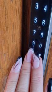 una persona con un mando a distancia con su pulgar en Apartment Sekulic, en Doboj