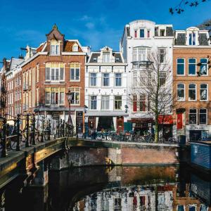 un pont sur une rivière dans une ville avec des bâtiments dans l'établissement Amsterdam Wiechmann Hotel, à Amsterdam