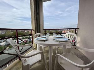 einen weißen Tisch und Stühle auf dem Balkon in der Unterkunft Appartement Rochefort, 2 pièces, 4 personnes - FR-1-246B-51 in Rochefort