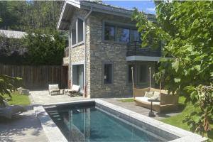 a house with a swimming pool in the yard at Chalet Ilulissat in Courchevel