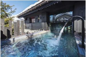 uma piscina com uma fonte de água em Le Hameau de Marcandou em Courchevel