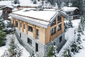 une maison avec de la neige sur le toit dans l'établissement Le Hameau de Marcandou, à Courchevel