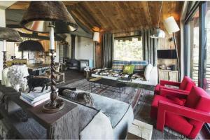 a living room with red chairs and a couch at Le Hameau de Marcandou in Courchevel