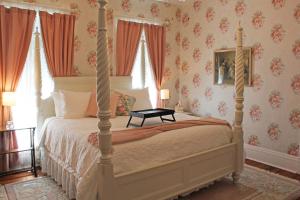 En eller flere senge i et værelse på Grand Victorian Manor & Cottage