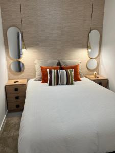 1 dormitorio con 1 cama blanca grande y 2 espejos en AMMO, en Olhão