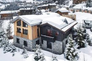 uma casa com neve no telhado em Chalet sisimut em Courchevel