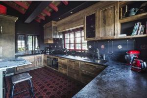 a kitchen with wooden cabinets and a red floor at Chalet sisimut in Courchevel