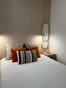 1 dormitorio con 1 cama con almohadas de color naranja y blanco en AMMO, en Olhão
