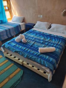 - 2 lits dans une chambre avec des serviettes dans l'établissement Guest house Amande, à Tinghir