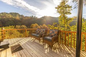 a deck with two chairs and a view of the mountains at Smoky Bear Lodge at Gr Smoky Mtn Park in Bryson City