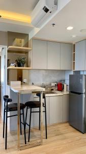 a kitchen with a table and chairs and a refrigerator at Two Bedroom Apartment at The Nove, Nuvasa Bay, Nongsa 719 in Nongsa