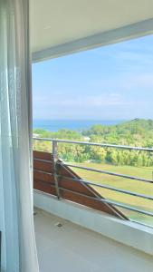 a balcony with a bench looking out at the ocean at Two Bedroom Apartment at The Nove, Nuvasa Bay, Nongsa 719 in Nongsa